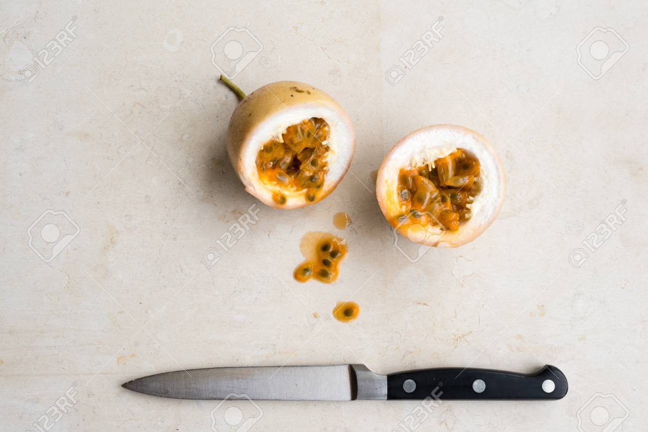 クリーム色の石灰岩の背景にナイフで半分にパナマ ゴールド パッション フルーツのハイアングル の写真素材 画像素材 Image 74971658