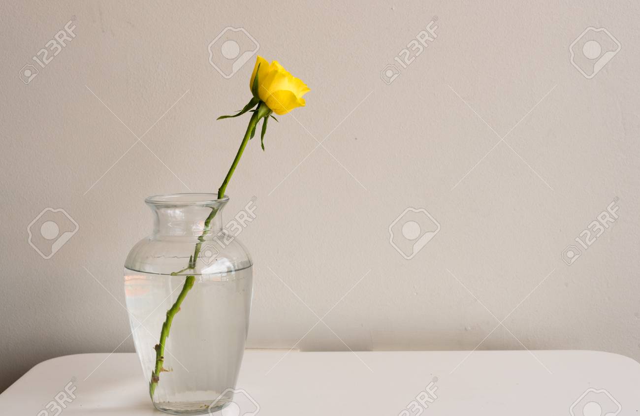 Single Yellow Rose In A Glass Vase On A White Table With Neutral