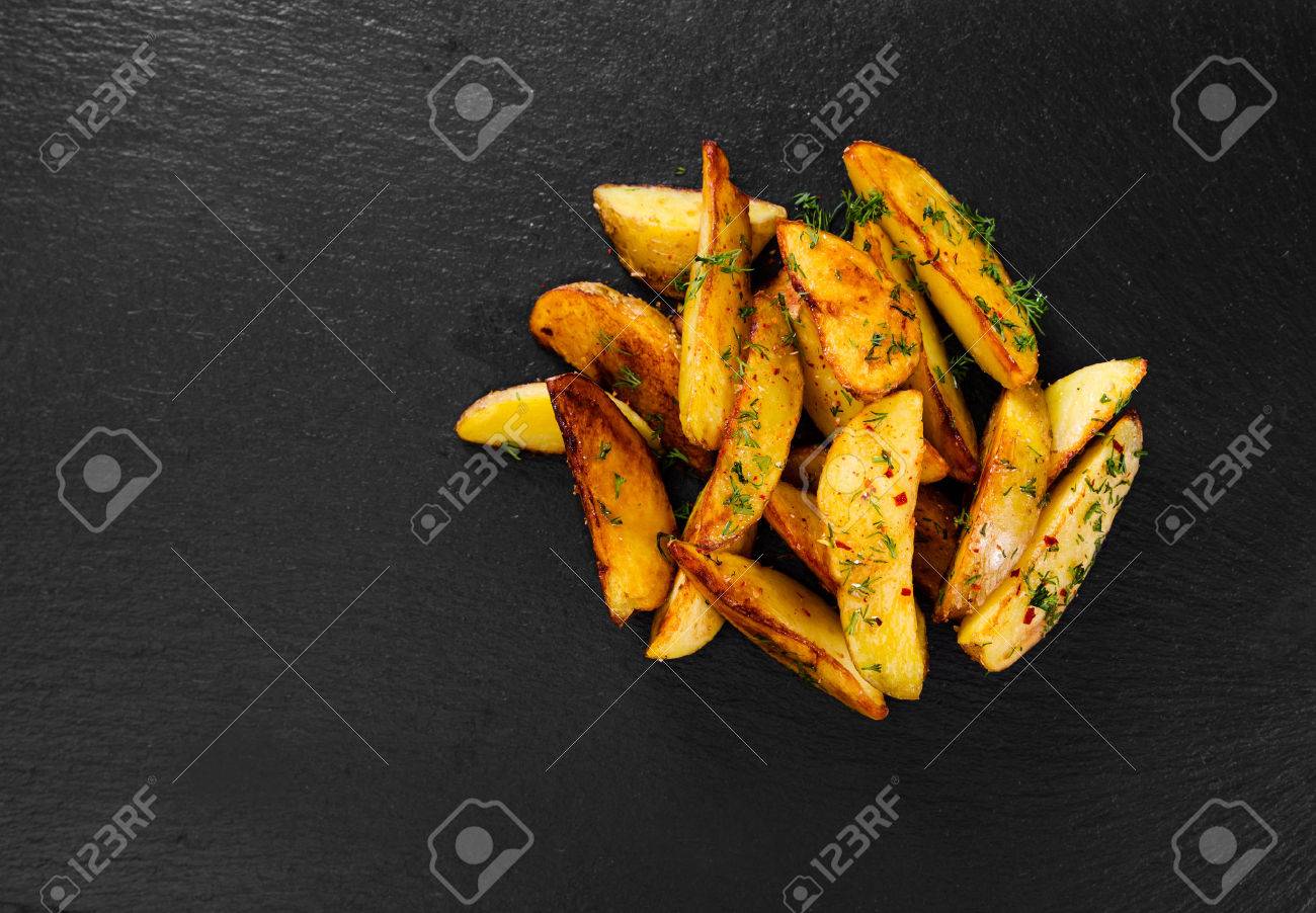 Potato wedges on black background. Top view. - 53723914 Potato wedges on black background. Top view. - 53723914