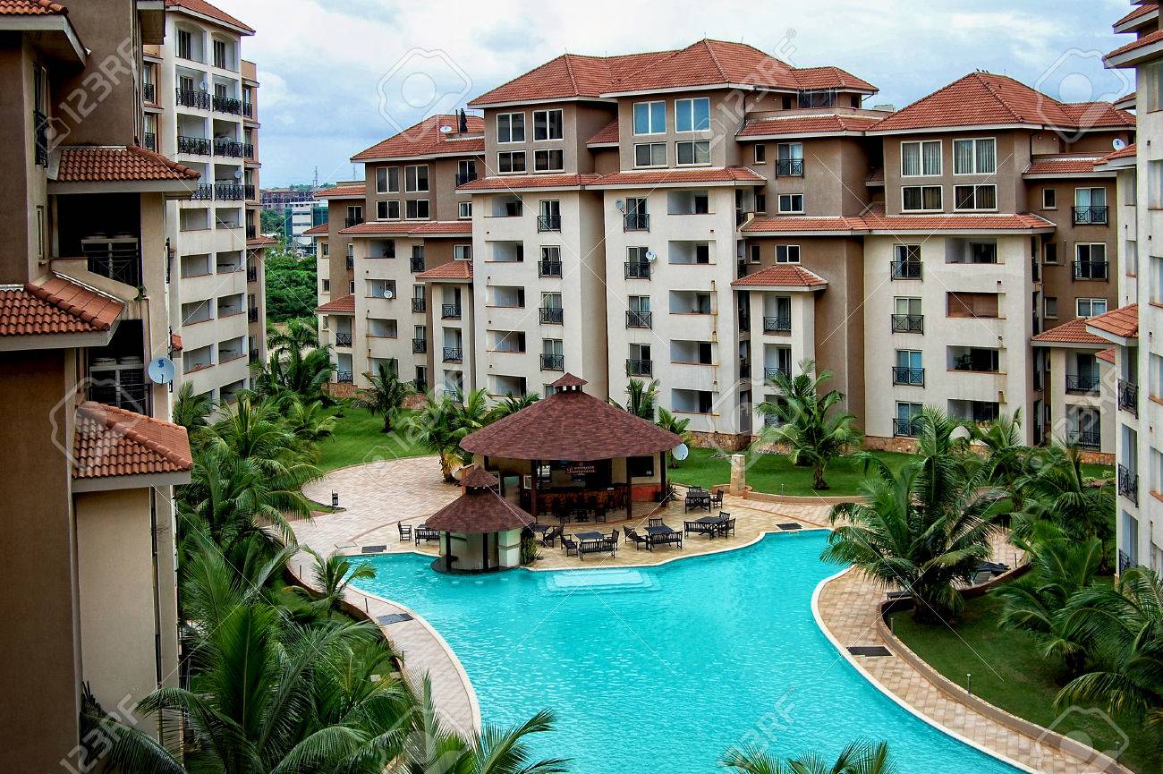 Accra. Ghana. West Africa. July 7, 2013 - Modern Residential Building In  Africa With An Outdoor Cafe, With A Beautiful Swimming Pool Surrounded By  Palm Trees On A Blue Sky Background. Villaggio., image size:1300x865