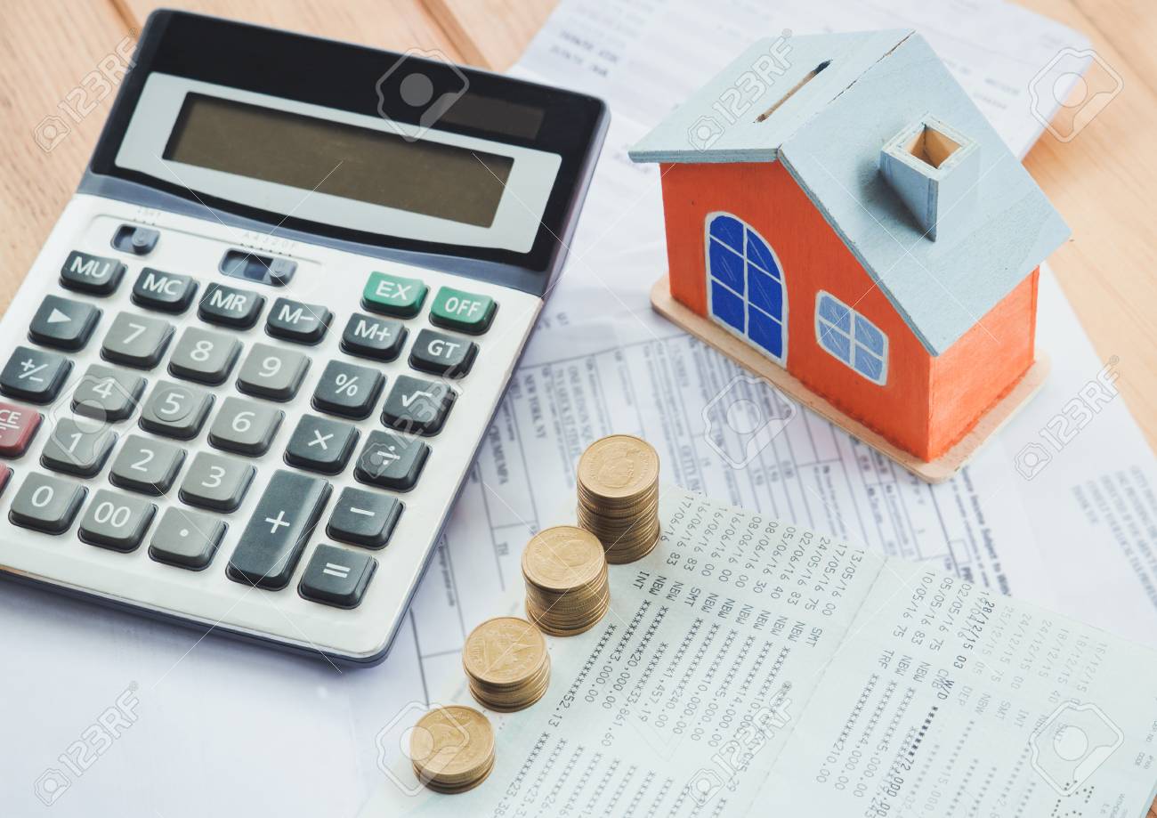 house model and coin on bank account calculator on table for