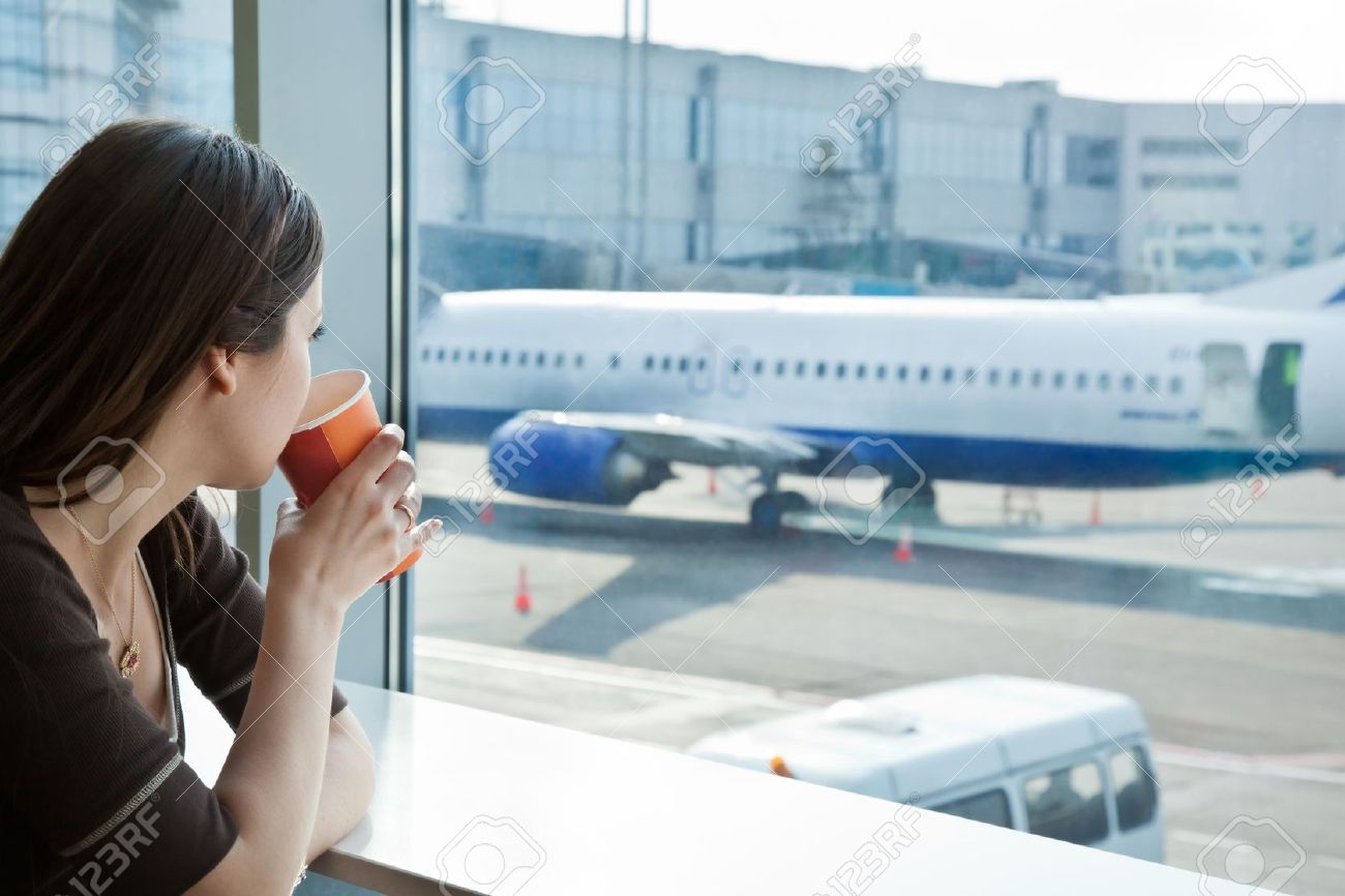 Young woman is drinking coffee in airport - 10874010 Young woman is drinking coffee in airport - 10874010