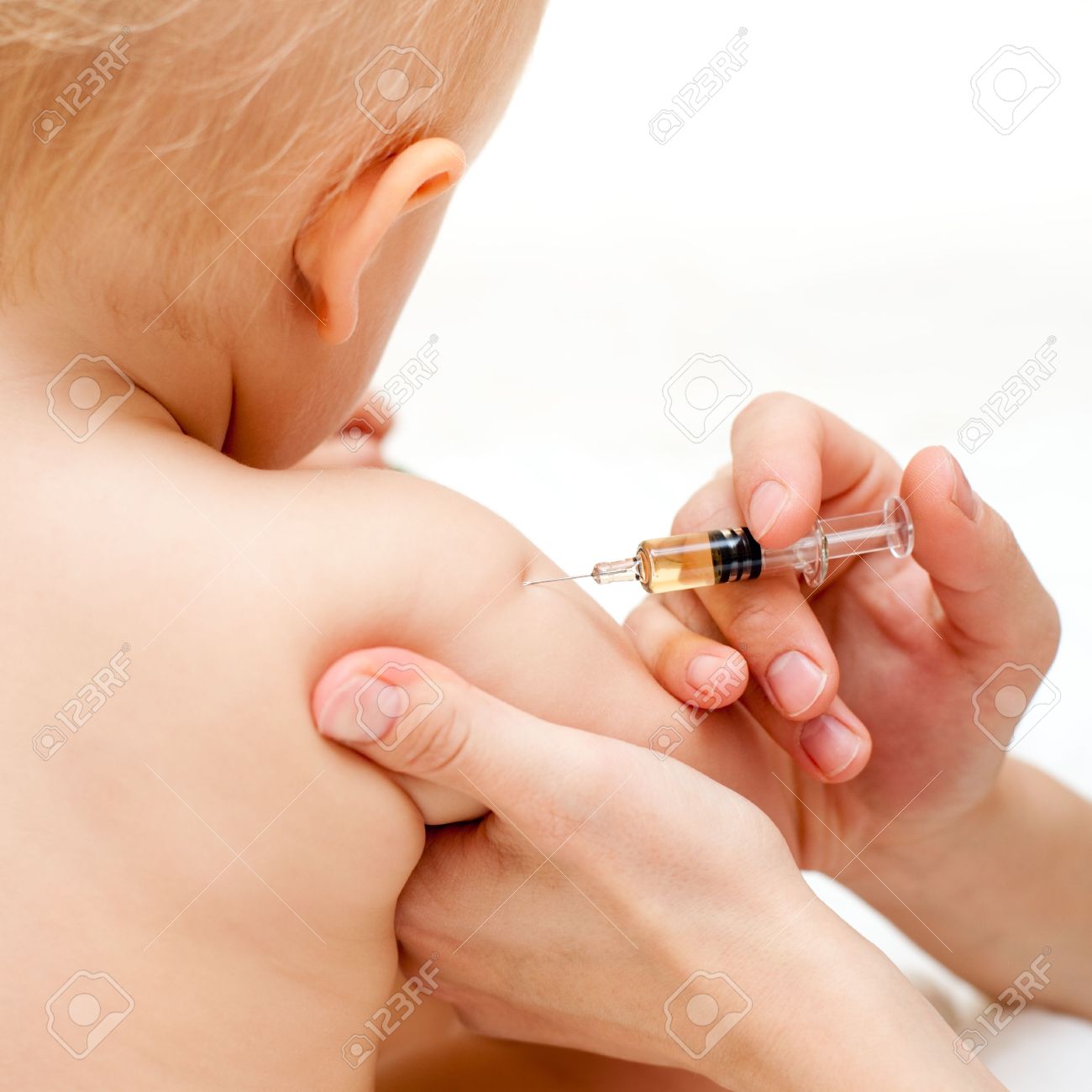 doctor giving a child an intramuscular injection in arm shallow