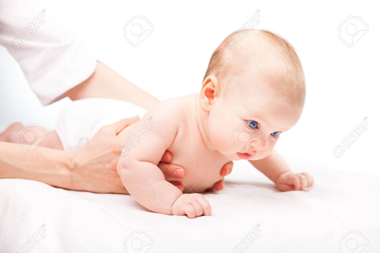 Three month baby girl is receiving back massage from a female massage therapist - 39763499 Three month baby girl is receiving back massage from a female massage therapist - 39763499