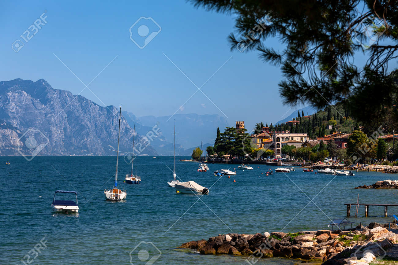 Pleasure boats moored near resort town on the eastern shore of Lake Garda in Northern Italy. Lake Garda is the largest lake in Italy and a popular holiday location on the edge of the Dolomites - 166389963 Pleasure boats moored near resort town on the eastern shore of Lake Garda in Northern Italy. Lake Garda is the largest lake in Italy and a popular holiday location on the edge of the Dolomites - 166389963