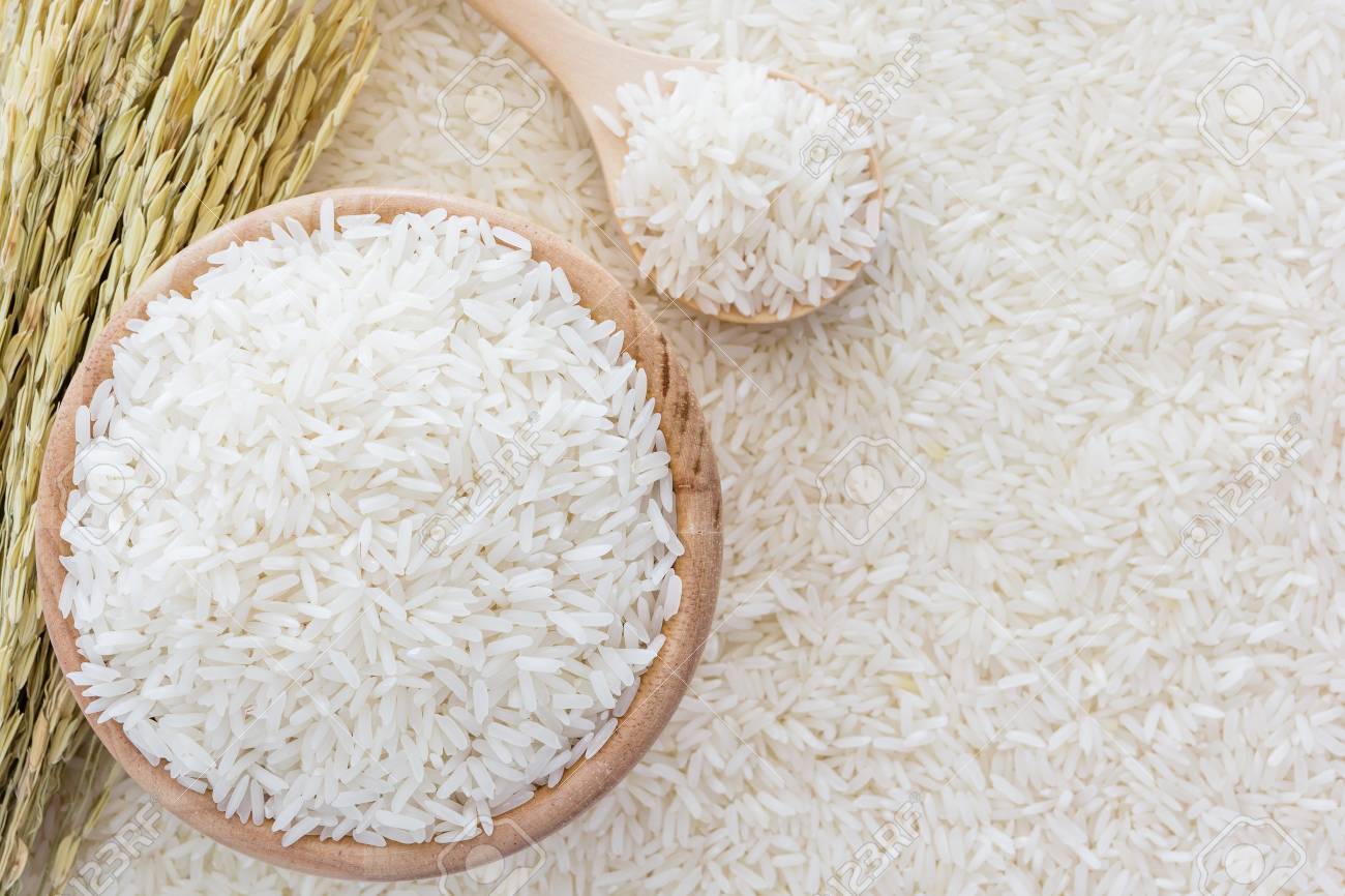 66833429-arroz-blanco-en-un-taz%C3%B3n-y-una-bolsa-una-cuchara-y-arroz-planta-de-madera-en-el-fondo-