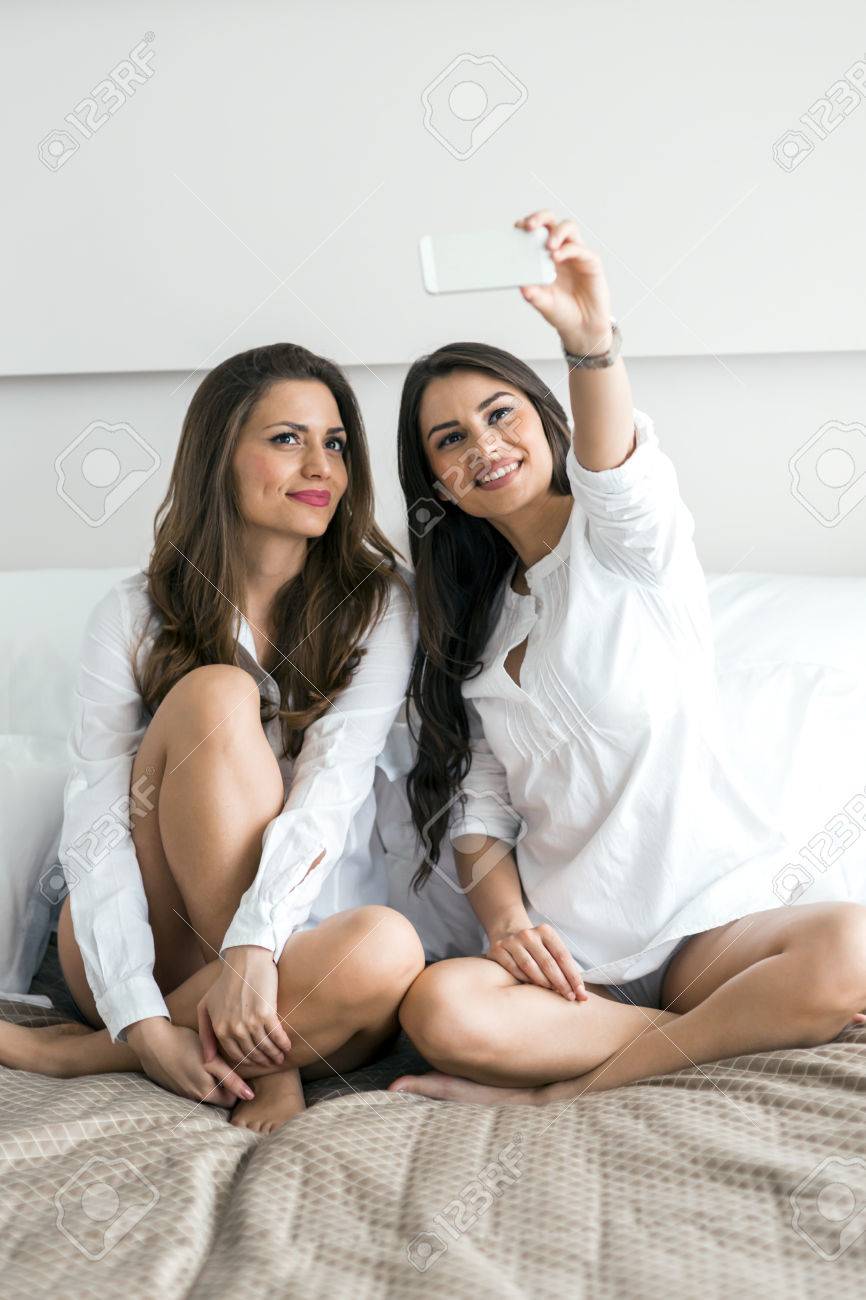 Due Belle Donne Che Si Trovano Su Un Letto Di Scattare Una Foto Di ... Due Belle Donne Che Si Trovano Su Un Letto Di Scattare Una Foto Di ...