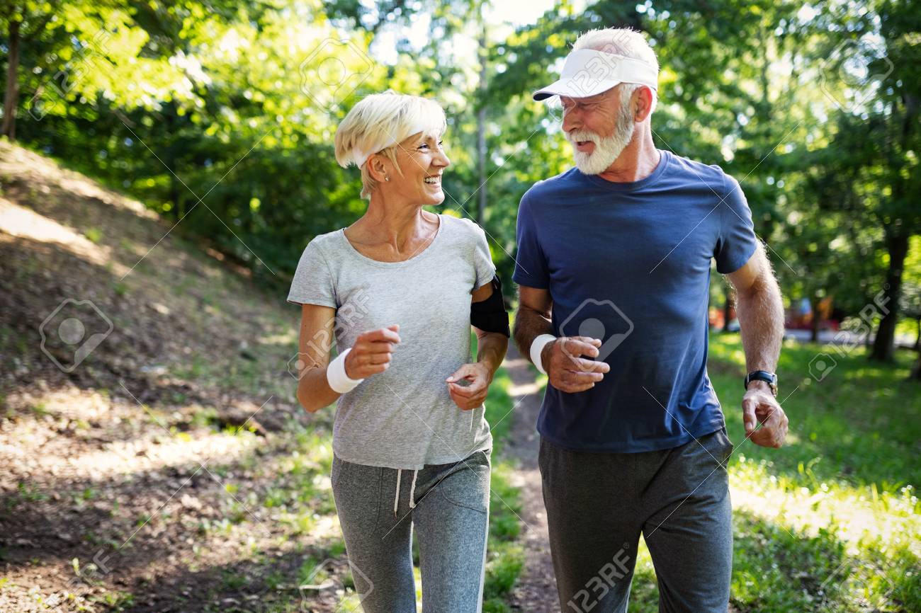 Mature couple jogging and running outdoors in city - 111508799 Mature couple jogging and running outdoors in city - 111508799