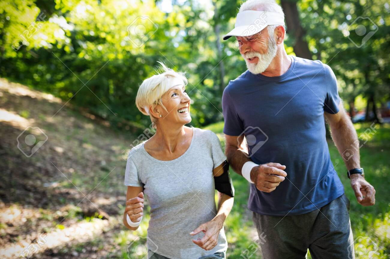 Mature couple jogging and running outdoors in nature - 124872182 Mature couple jogging and running outdoors in nature - 124872182
