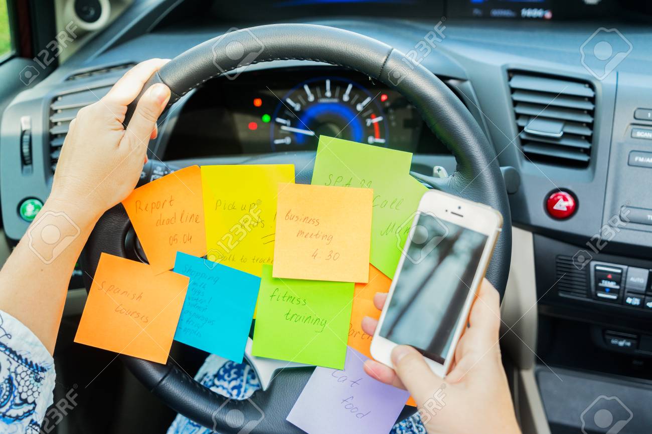 To do list in a car on driving wheel and hand holding phone - busy day concept - 76972011 To do list in a car on driving wheel and hand holding phone - busy day concept - 76972011