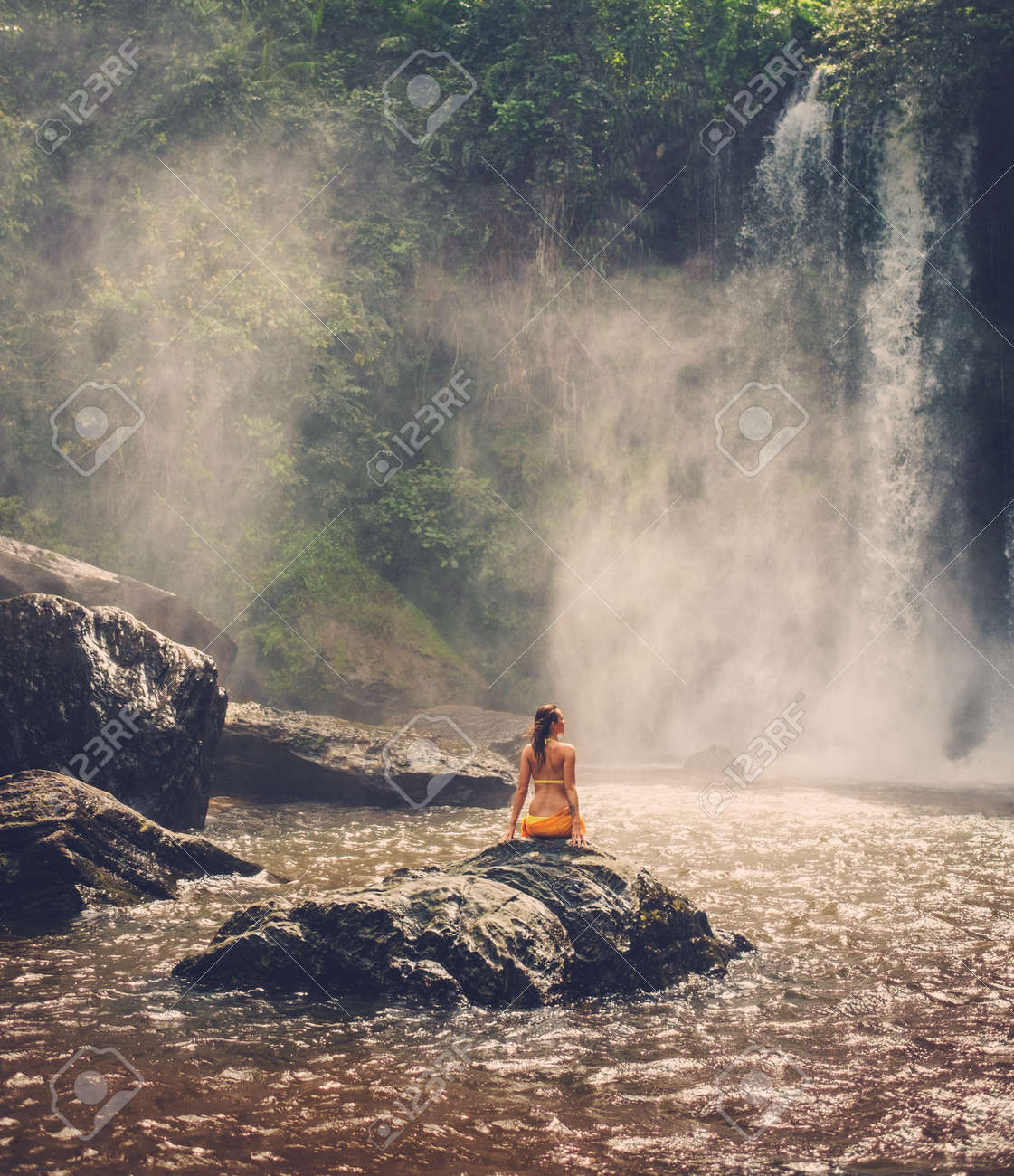 Beautiful woman sitting near waterfall enjoying the sun, Phnom Koulen at Siem Reap, Cambodia - 49591444 Beautiful woman sitting near waterfall enjoying the sun, Phnom Koulen at Siem Reap, Cambodia - 49591444