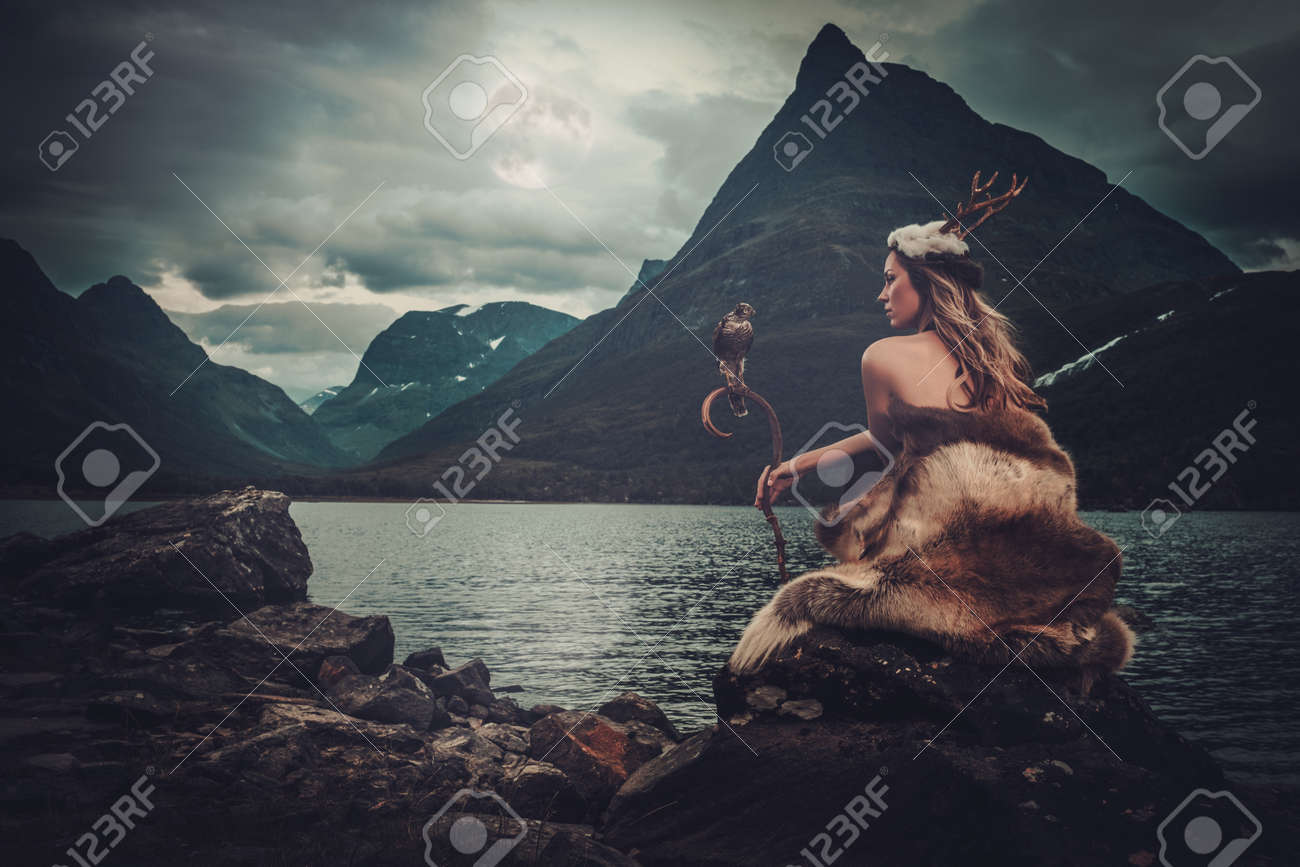 Nordic goddess in ritual garment with hawk near wild mountain lake in Innerdalen valley, Norway. - 60870755 Nordic goddess in ritual garment with hawk near wild mountain lake in Innerdalen valley, Norway. - 60870755