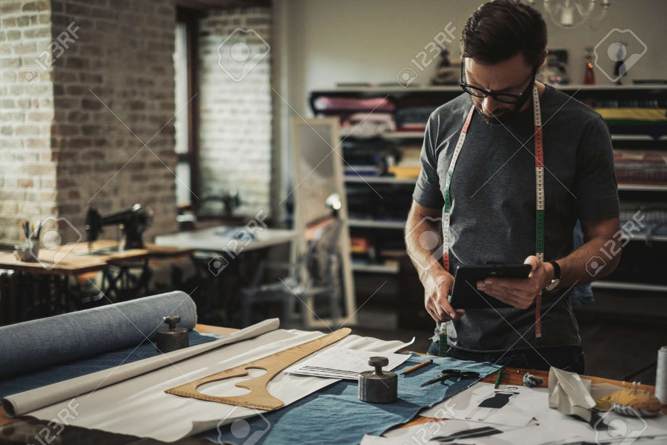 Fashion designer working in his studio - 124309526 Fashion designer working in his studio - 124309526