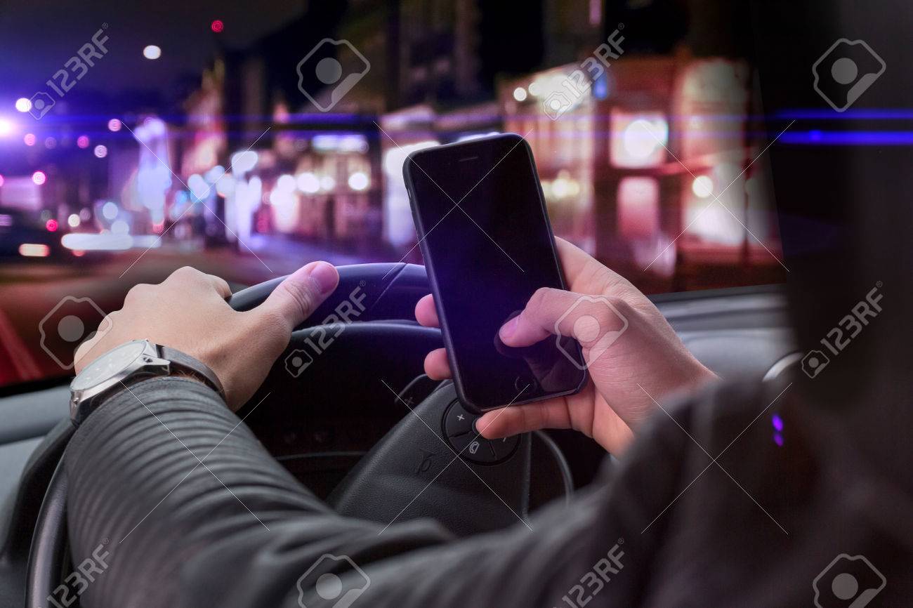 young man holding a smartphone while driving. dangerous travel situation with distraction from street - 47693968 young man holding a smartphone while driving. dangerous travel situation with distraction from street - 47693968
