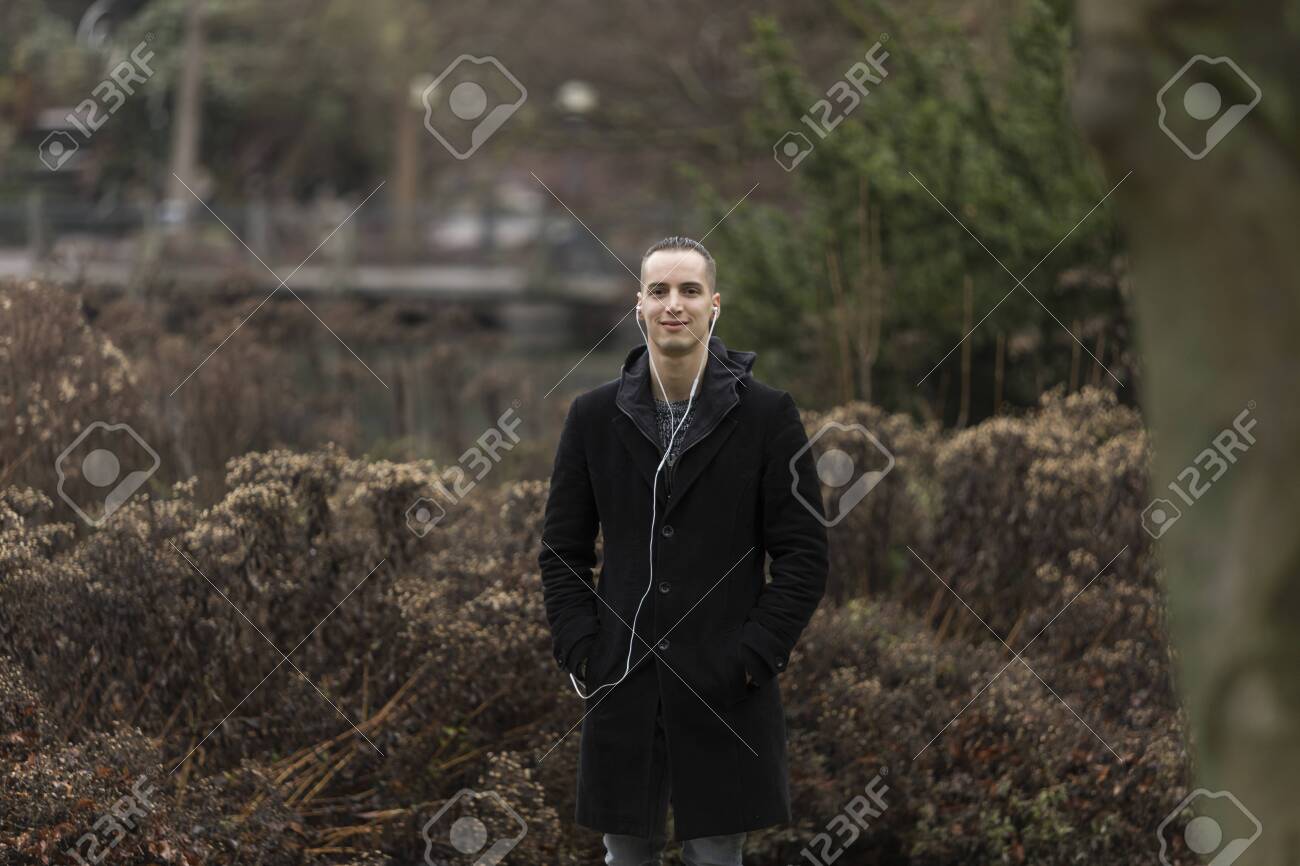 Portrait of Young Man Standing in Park - 143965837 Portrait of Young Man Standing in Park - 143965837