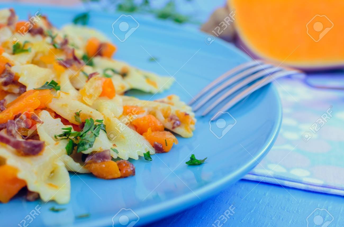 イタリアの全粒粉パスタ ファルファッレ バターナット カボチャと生ハム パスタ カボチャ ソース ベーコン 新鮮なパセリの青い木製の背景に イタリア料理のコンセプトです 選択と集中 の写真素材 画像素材 Image