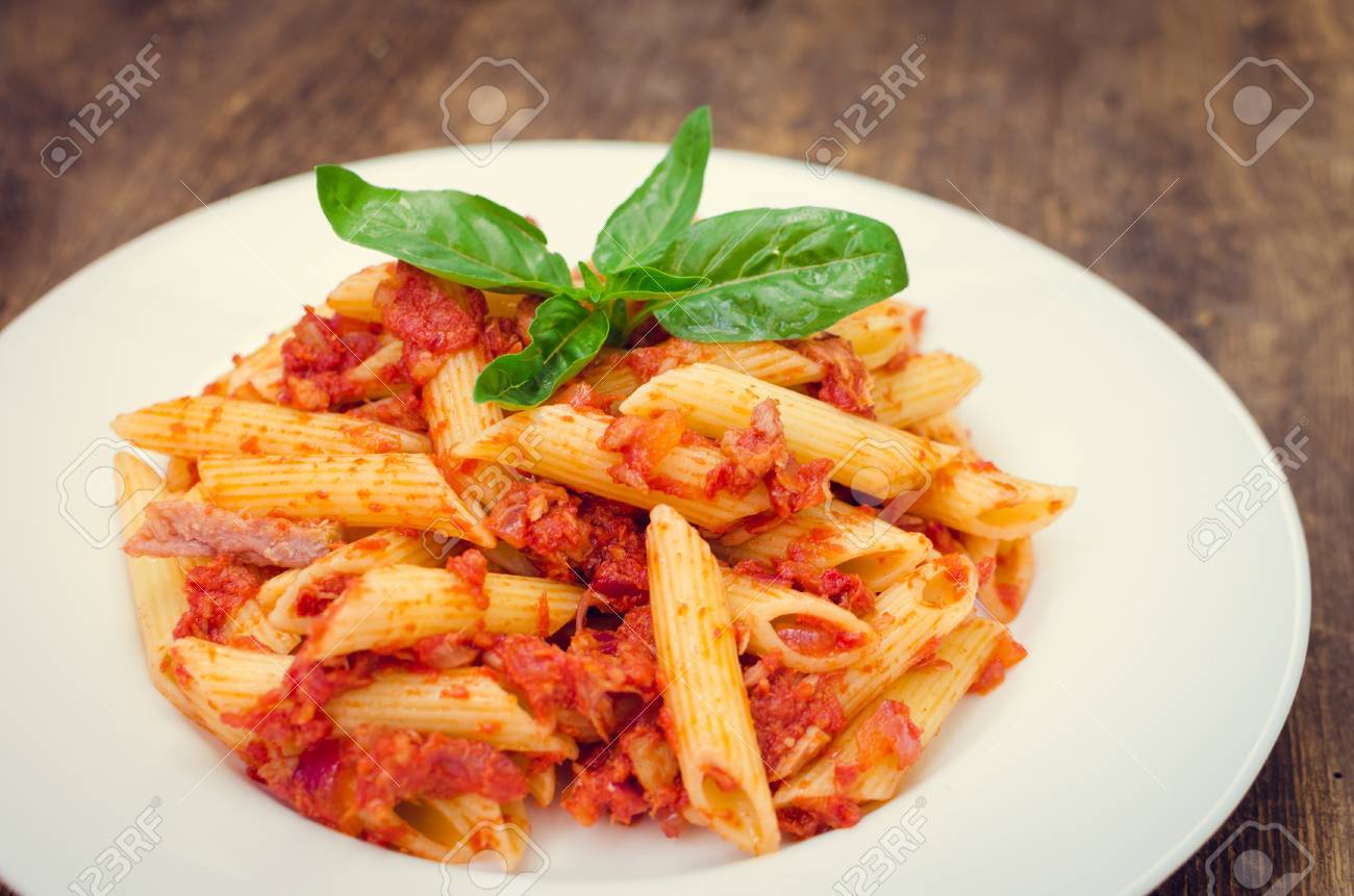 イタリアの全粒粉パスタ ツナとバジルのペンネ古い木製の背景にマグロとトマトのソースのパスタ イタリア料理のコンセプトです 選択と集中 の写真素材 画像素材 Image