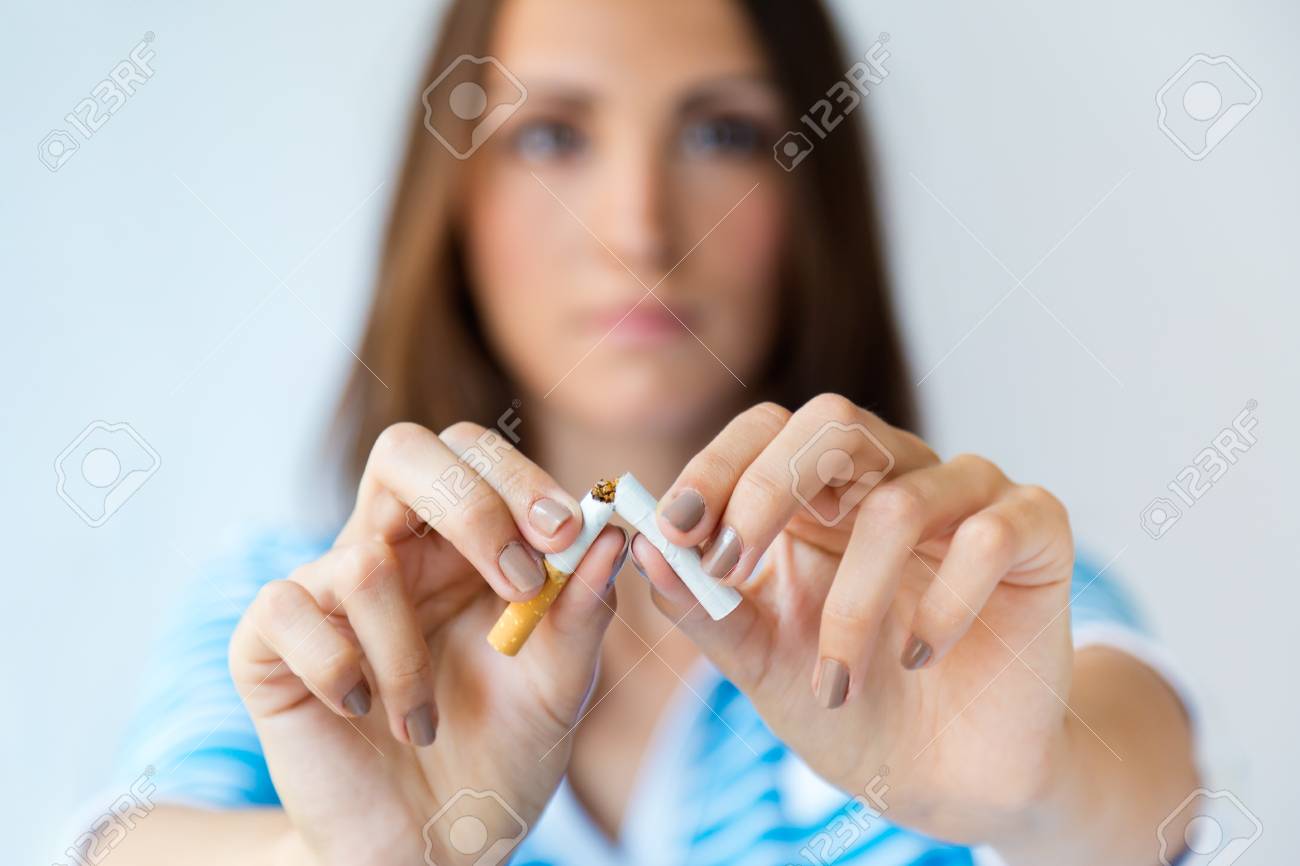 Portrait of young woman refuses to smoke and breaks cigarette. - 111657576 Portrait of young woman refuses to smoke and breaks cigarette. - 111657576