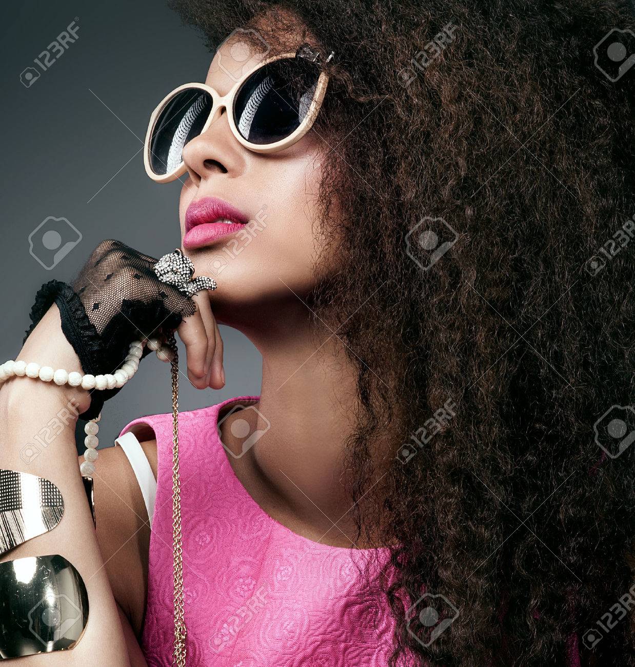 美しいエレガントなアフリカ系アメリカ人女性のファッション写真 流行のサングラスを身に着けている宝石類の多くのポーズの女の子 長い巻き毛の健康な髪を持つ少女 美しさの肖像画 スタジオ撮影します の写真素材 画像素材 Image
