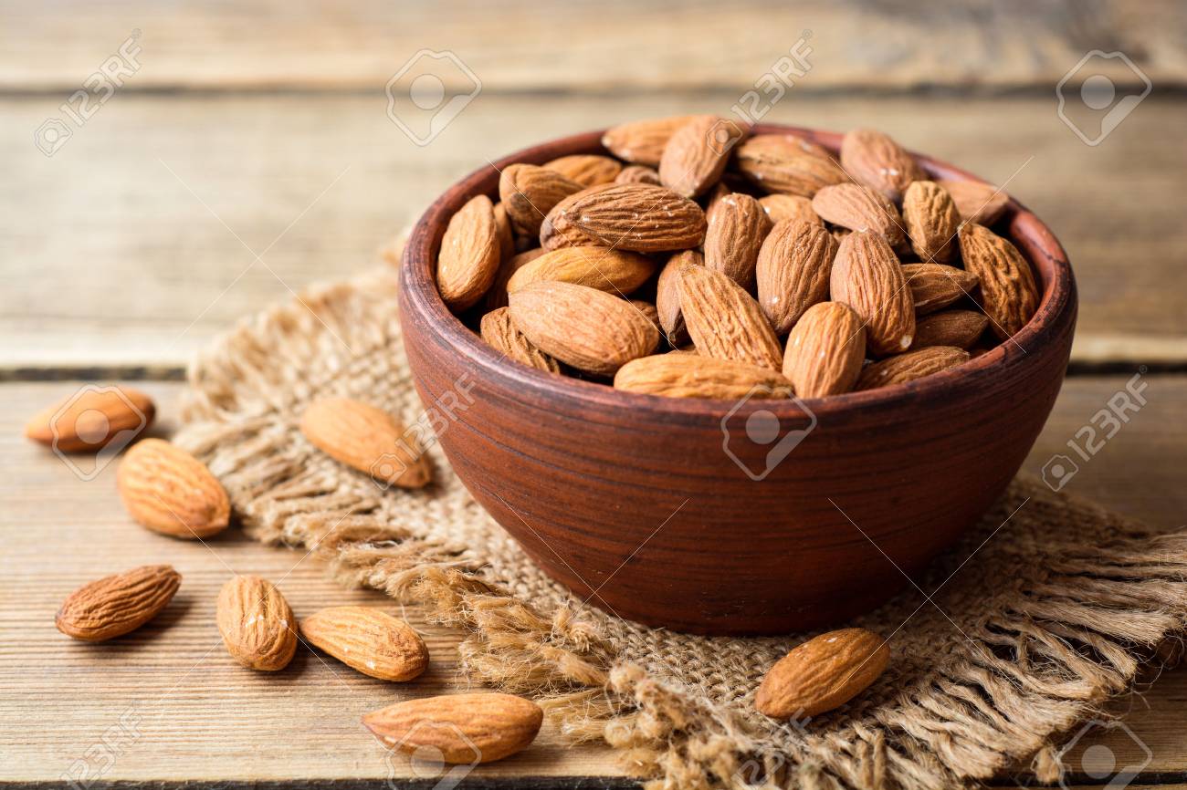 Almonds in ceramic bowl on wooden background. Selective focus. - 80896968 Almonds in ceramic bowl on wooden background. Selective focus. - 80896968