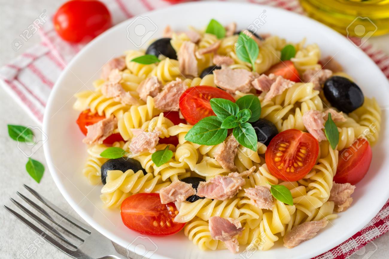 Fusilli pasta salad with tuna, tomatoes, black olives and basil on gray stone background. Selective focus. - 84623404 Fusilli pasta salad with tuna, tomatoes, black olives and basil on gray stone background. Selective focus. - 84623404