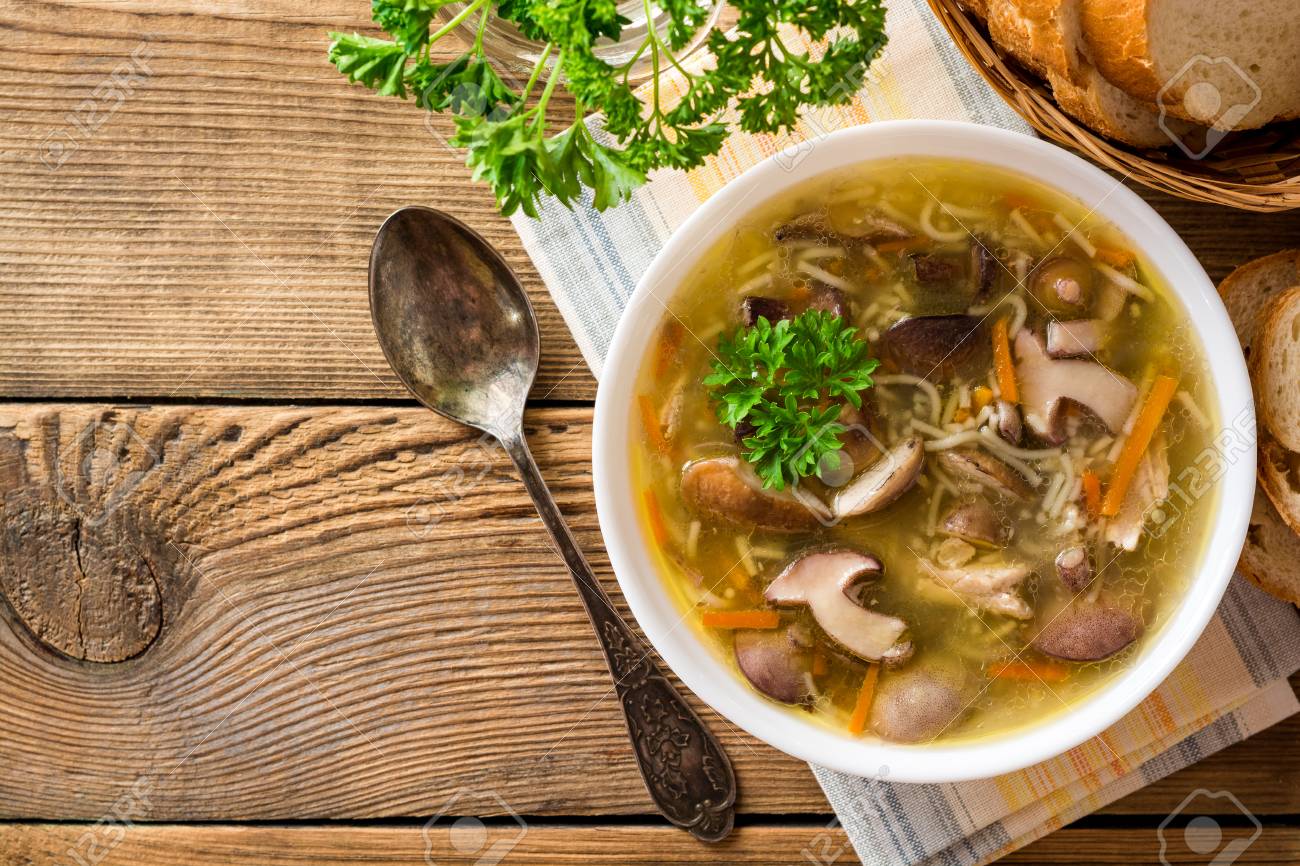 Chicken soup with mushrooms and noodles on rustic wooden table. Top view. - 87166543 Chicken soup with mushrooms and noodles on rustic wooden table. Top view. - 87166543