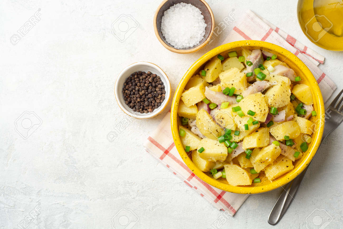 Potato salad with salted herring and onion in ceramic bowl on concrete background. Top view, copy space. - 164198567 Potato salad with salted herring and onion in ceramic bowl on concrete background. Top view, copy space. - 164198567