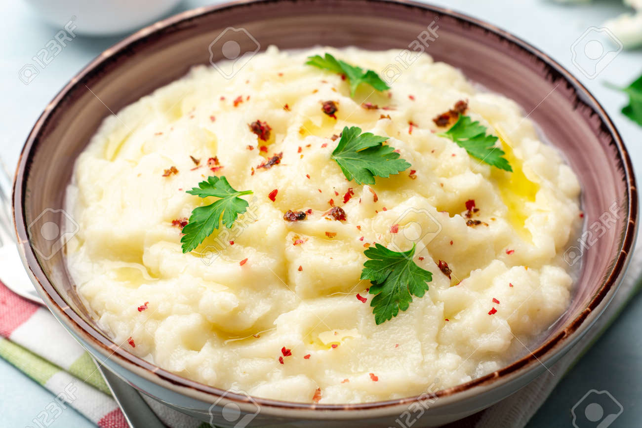 Mashed cauliflower with butter, pink peppercorns and parsley on concrete background. Selective focus. - 164184567 Mashed cauliflower with butter, pink peppercorns and parsley on concrete background. Selective focus. - 164184567