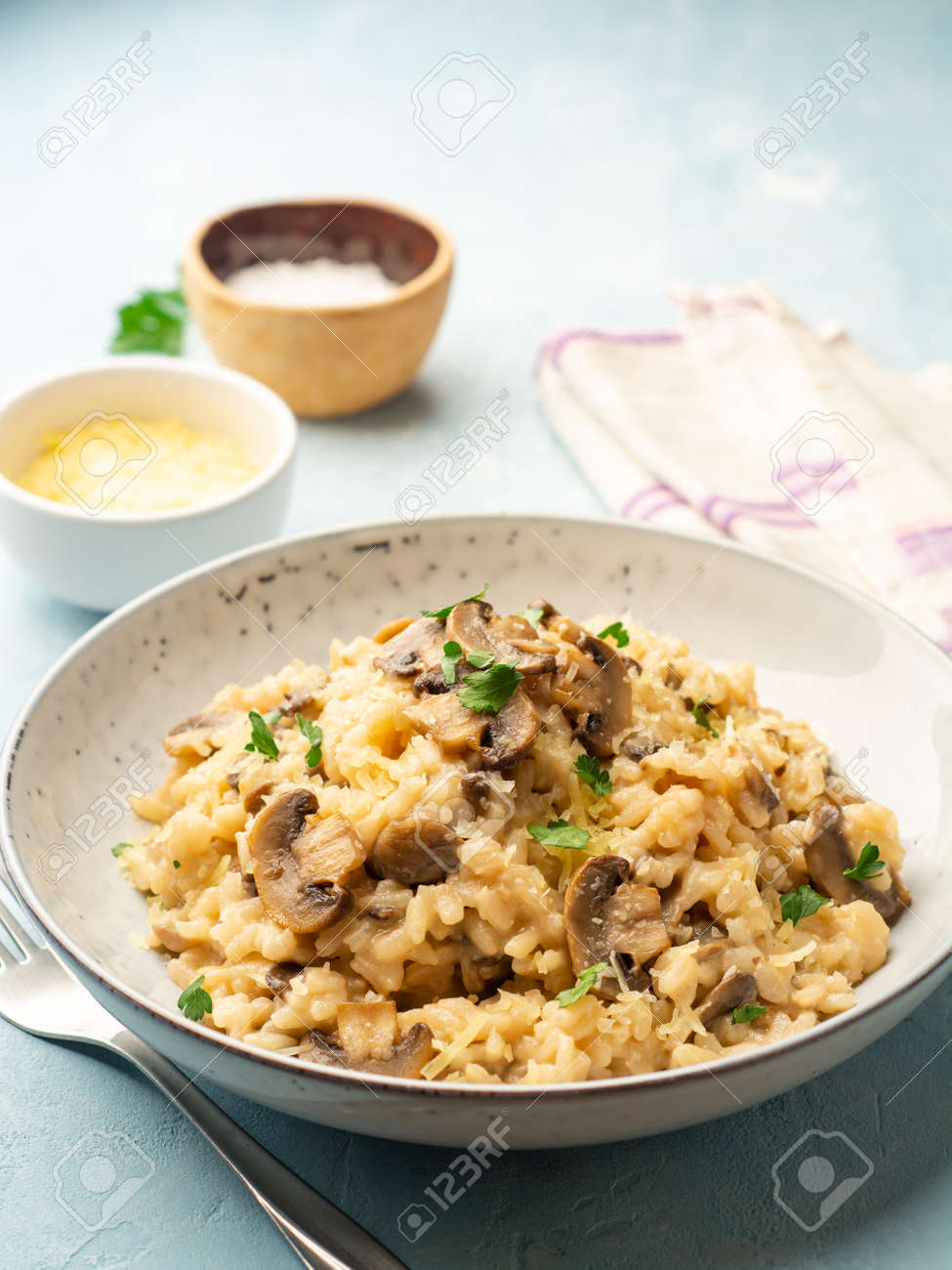 Risotto with mushrooms, parmesan cheese and parsley in plate. - 169457398 Risotto with mushrooms, parmesan cheese and parsley in plate. - 169457398