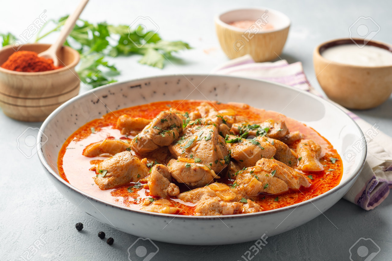 Chicken stew with paprika, onion and sour cream in plate - 169457491 Chicken stew with paprika, onion and sour cream in plate - 169457491