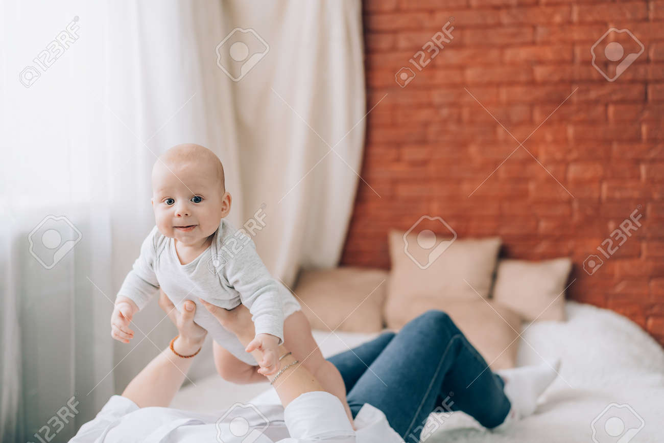 Young mother holding her newborn baby in her arms. Love and care for children. - 169603057 Young mother holding her newborn baby in her arms. Love and care for children. - 169603057