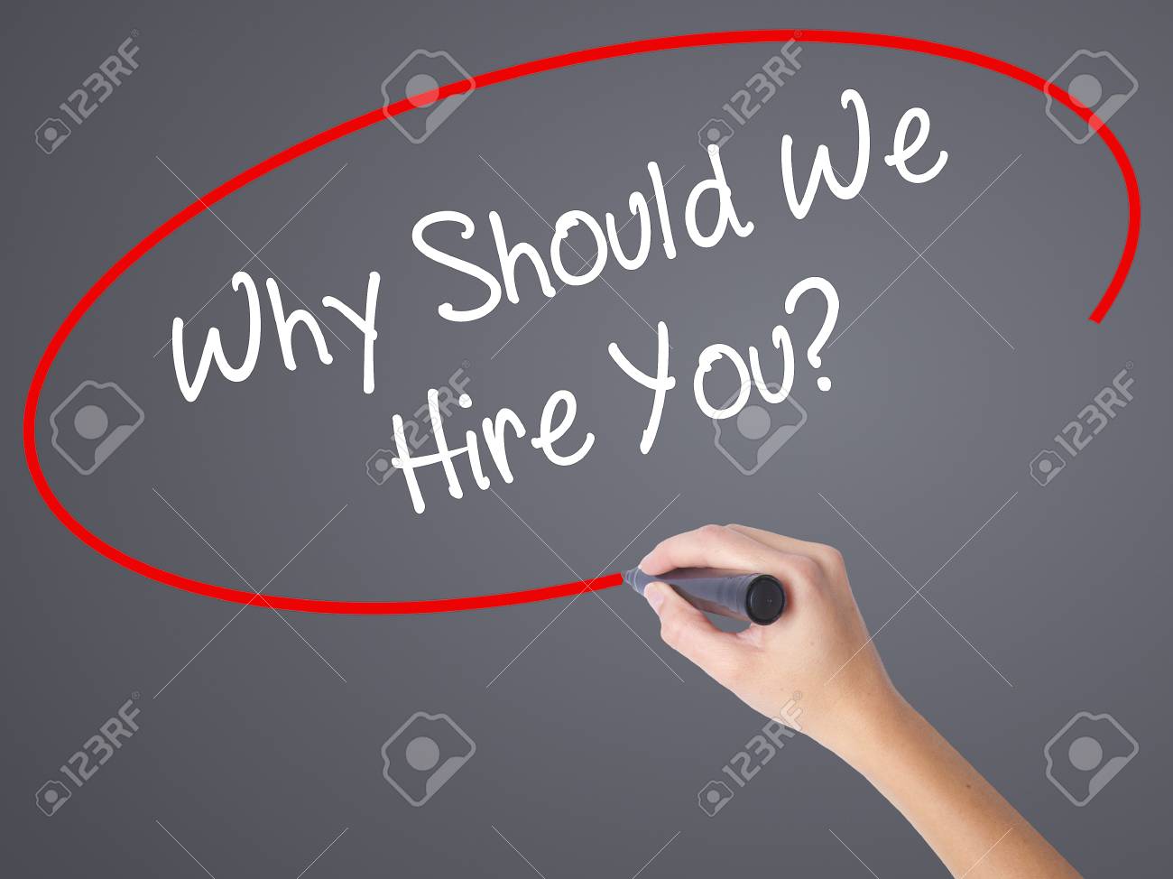 woman hand writing why should we hire you with black marker stock