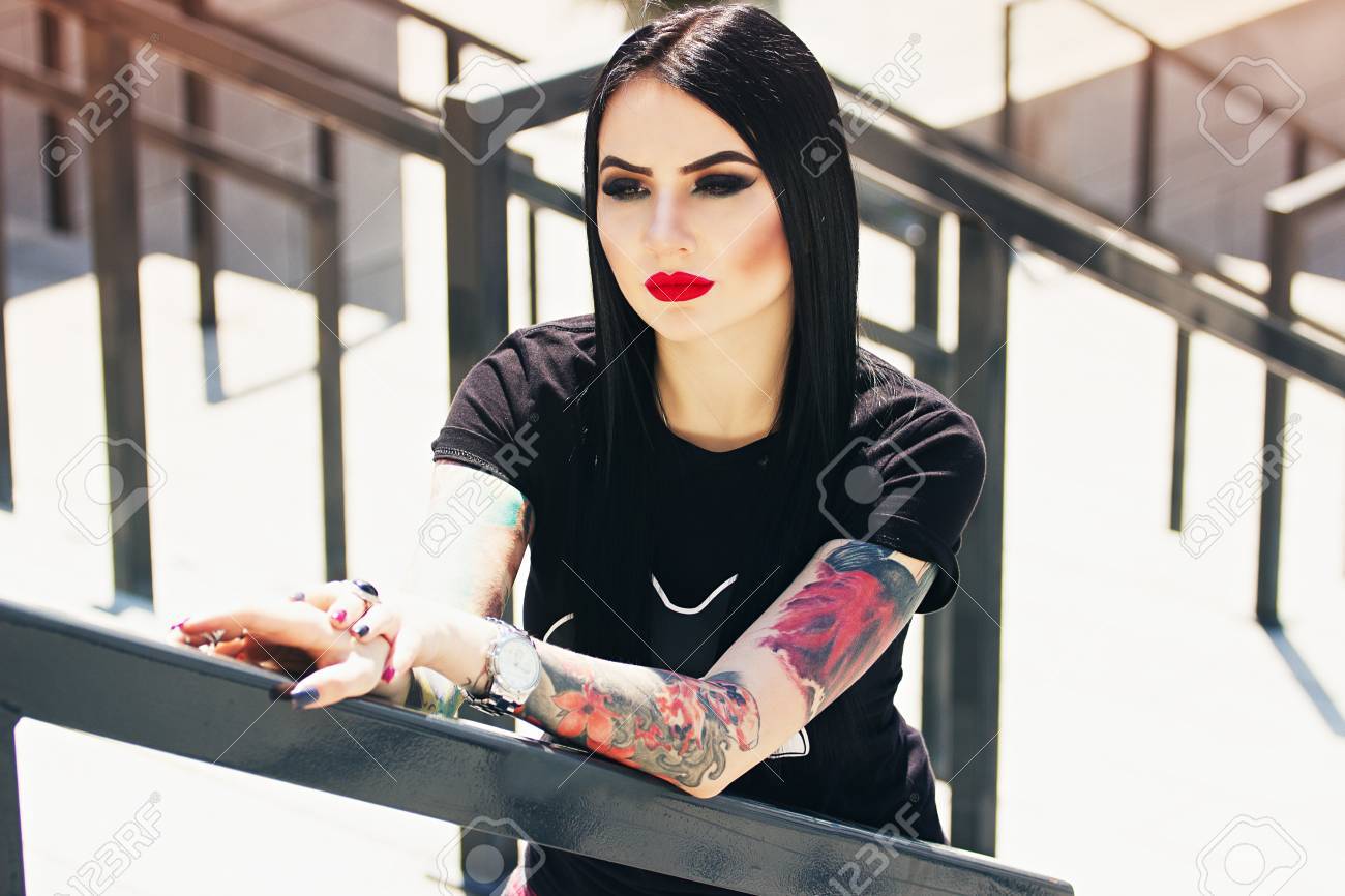 Tattoo Fashion. Portrait Of Fashionable Tattoed Hipster Girl With Red Lips  Posing Against Urban Background. Stock Photo, Picture and Royalty Free  Image. Image 78034344.