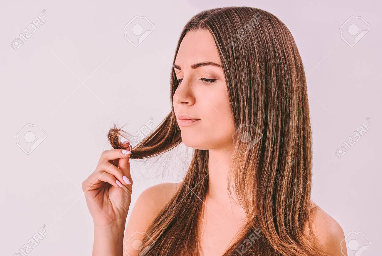 Portrait Of Young Frustrated Woman Looking At Dry Split Hair Stock Photo Picture And Royalty Free Image Image 145292989
