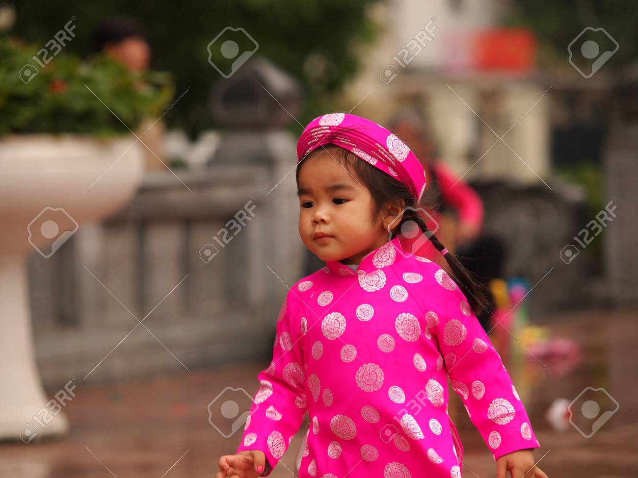 アオザイ　子供 ホーチミン市、ベトナム南-FEB16: 伝統的な祭りの衣装にハンサムなアジアの女の子の肖像画。かわいいベトナム少女アオザイ  ドレス笑顔で。テト休日。旧正月ベトナム、2015 年 2 月 16 日の写真素材・画像素材 Image 55061553