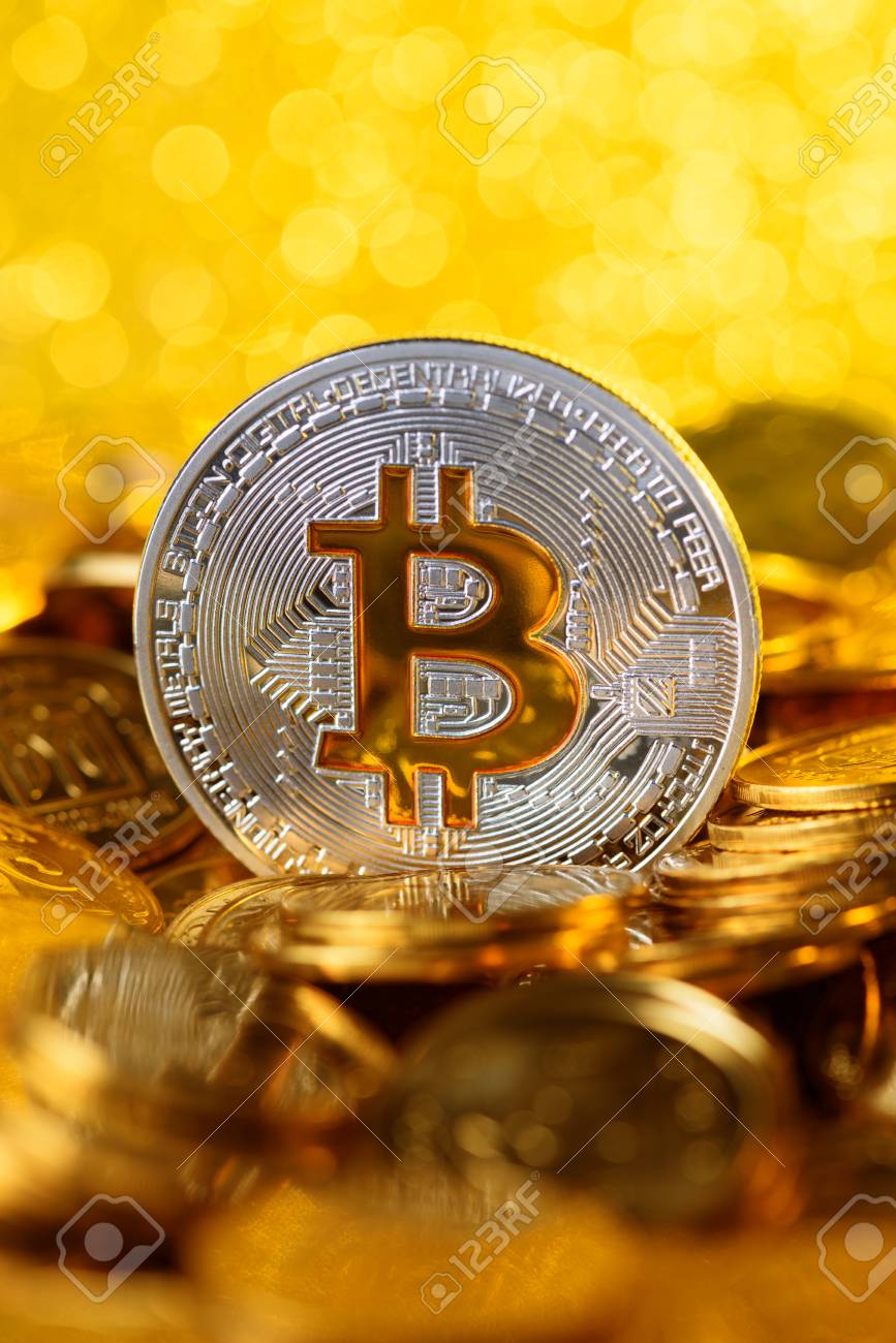 Bitcoin Na Pilha De Moedas De Ouro, Grande Moeda De Prata Com Símbolo De  Ouro Bit, Vertical Com Espaço De Cópia E Fundo De Luzes Brilhantes Foto  Royalty Free, Gravuras, Imagens e