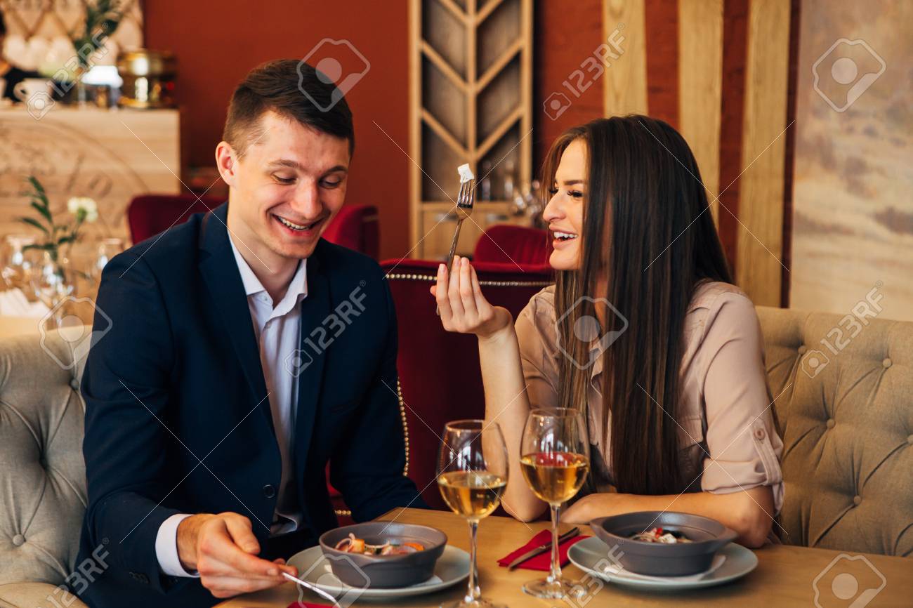 happy couple having dinner at restaurant and laughing - 97567471 happy couple having dinner at restaurant and laughing - 97567471