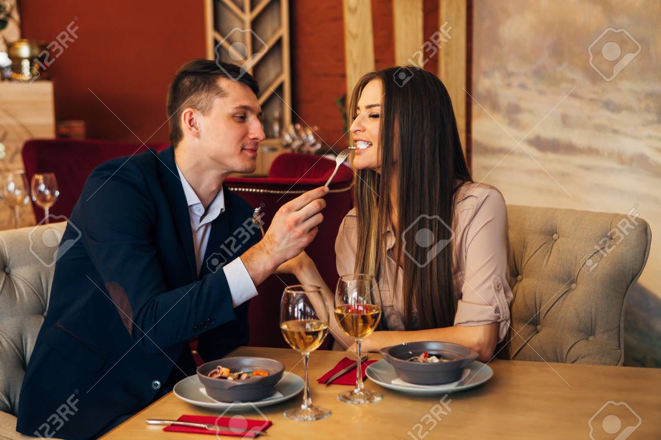 a man feeds his woman in a restaurant - 97567474 a man feeds his woman in a restaurant - 97567474