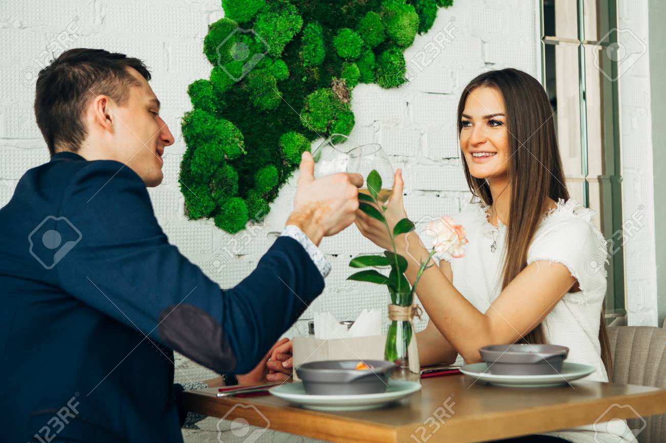 smiling couple having dinner and drinking white wine at date in restaurant - 97567493 smiling couple having dinner and drinking white wine at date in restaurant - 97567493