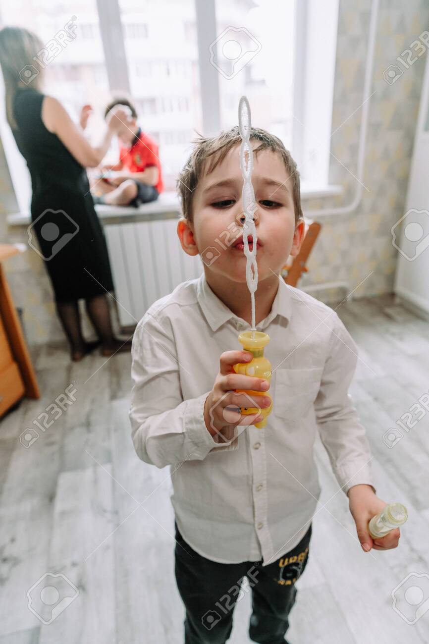Child playing with soap bubbles in the home - 145784008 Child playing with soap bubbles in the home - 145784008