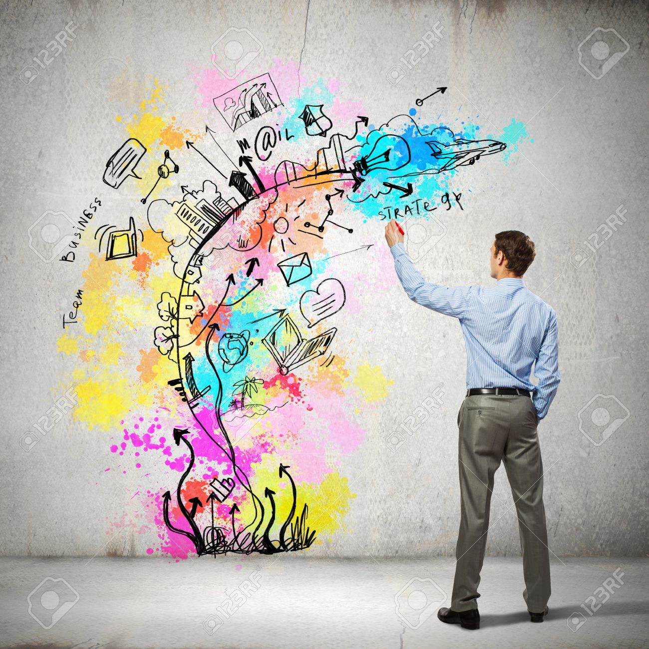 back view of businessman drawing colorful business ideas on wall back view of businessman drawing colorful business ideas on wall