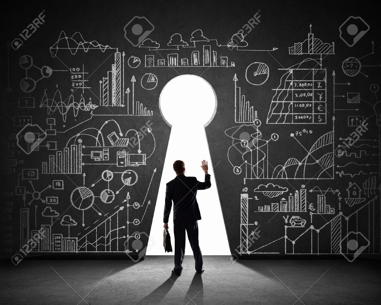 Silhouette of businessman against black wall with key hole - 21644034 Silhouette of businessman against black wall with key hole - 21644034