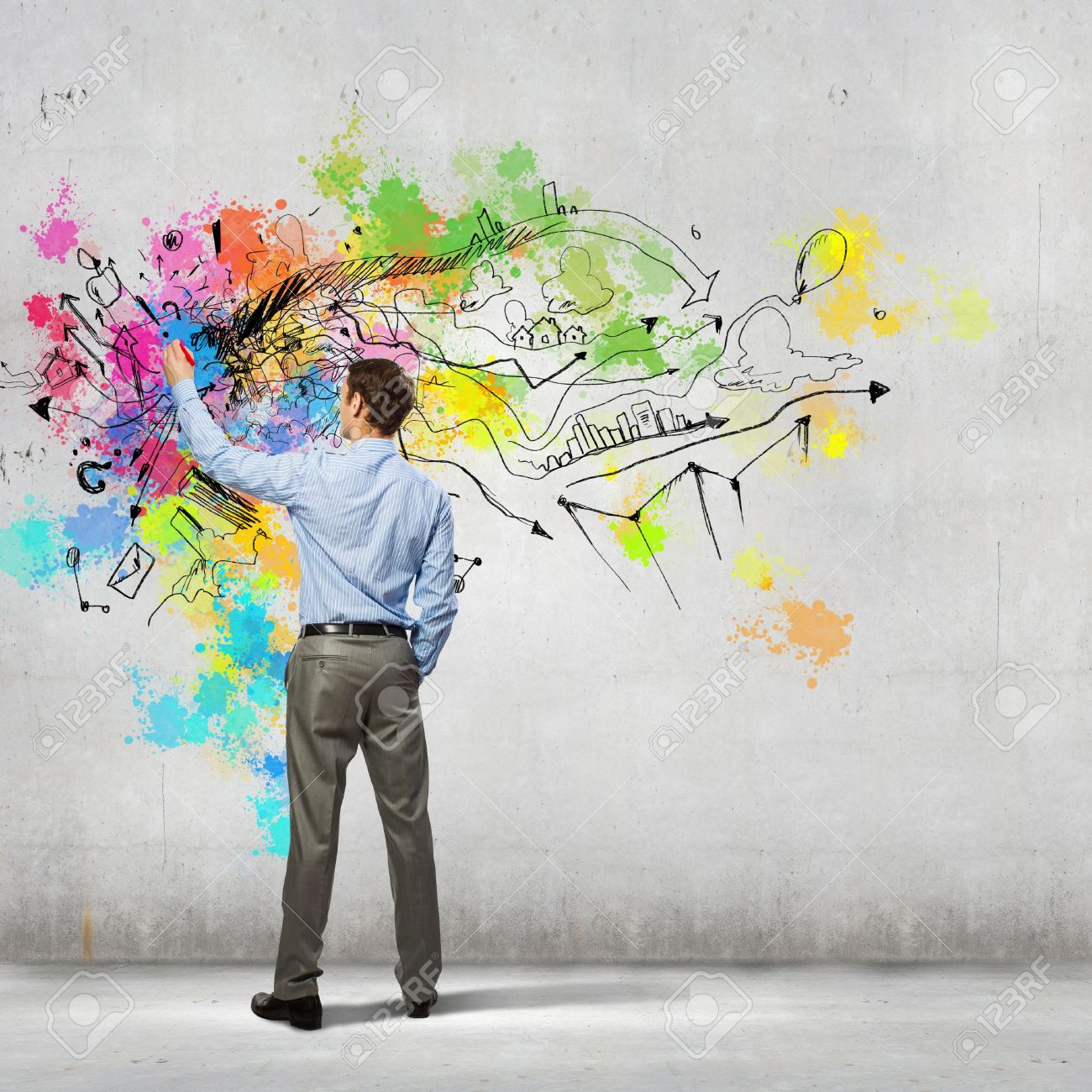 back view of businessman drawing colorful business ideas on wall back view of businessman drawing colorful business ideas on wall