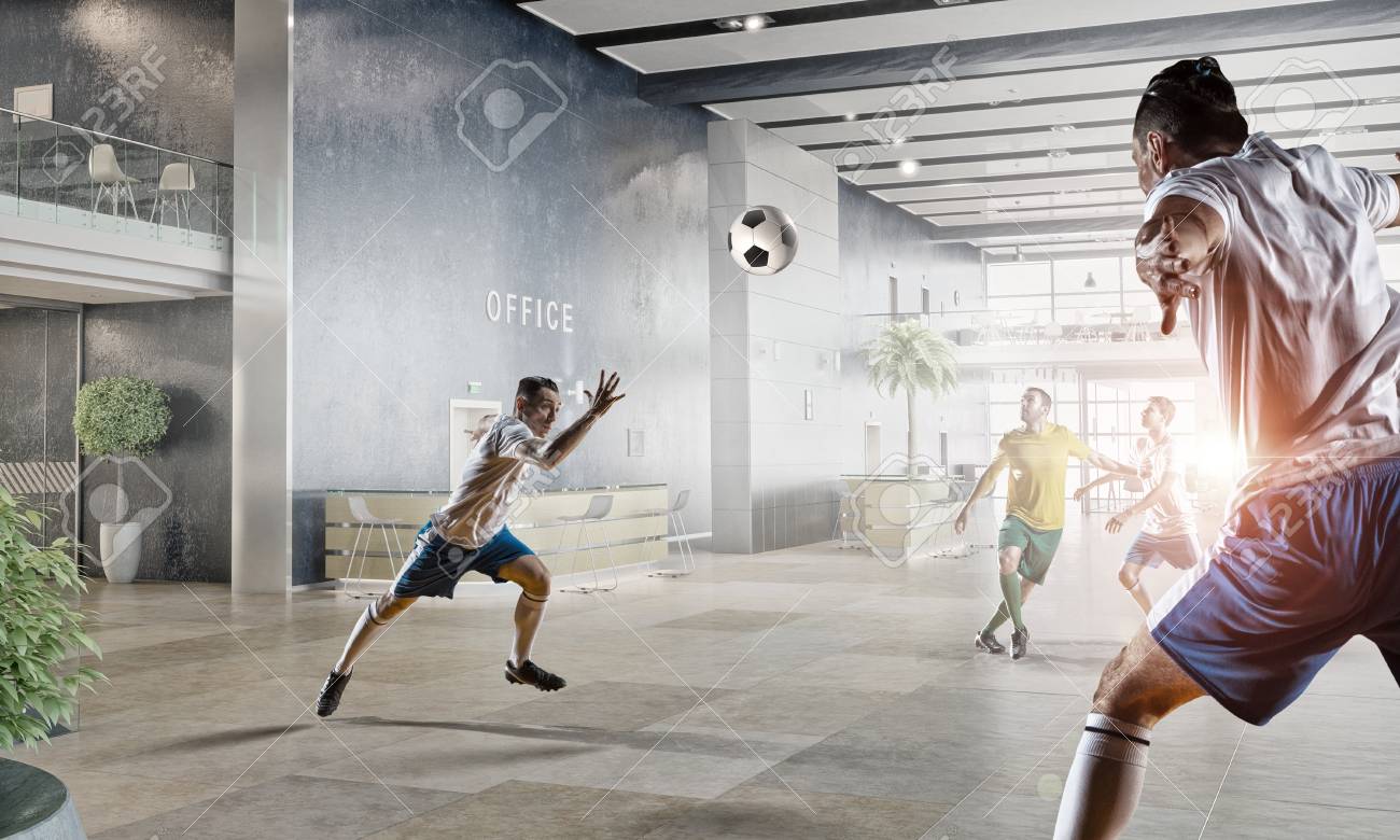 players and businessman playing soccer ball in modern office stock photo 59635696