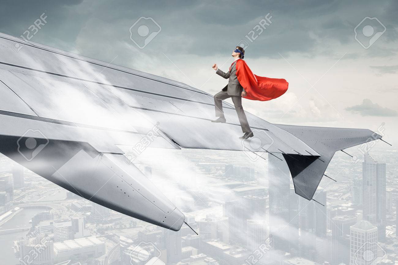 61098518-Super-man-standing-on-edge-of-airplane-wing-Stock-Photo.jpg