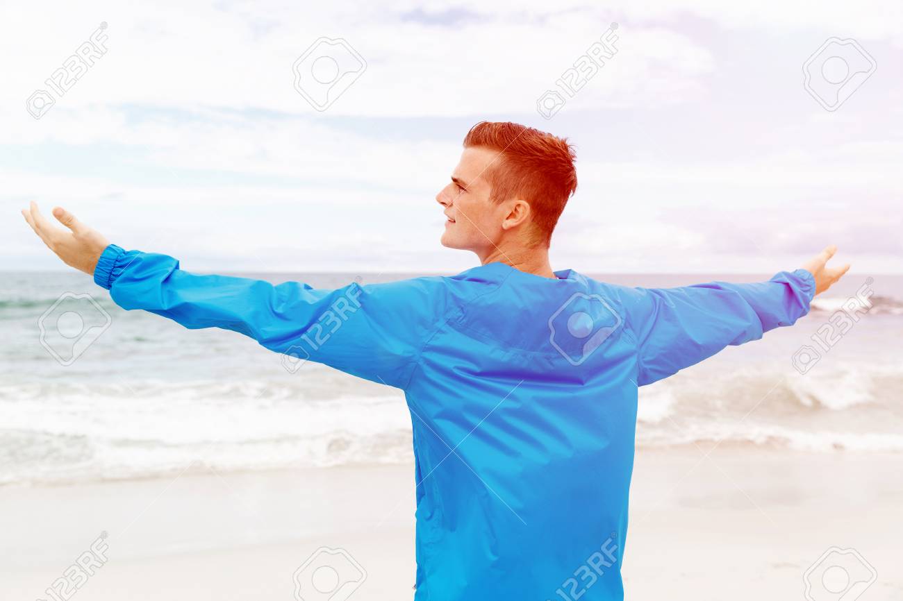 young man in sport wear with outstretched arms stock photo picture