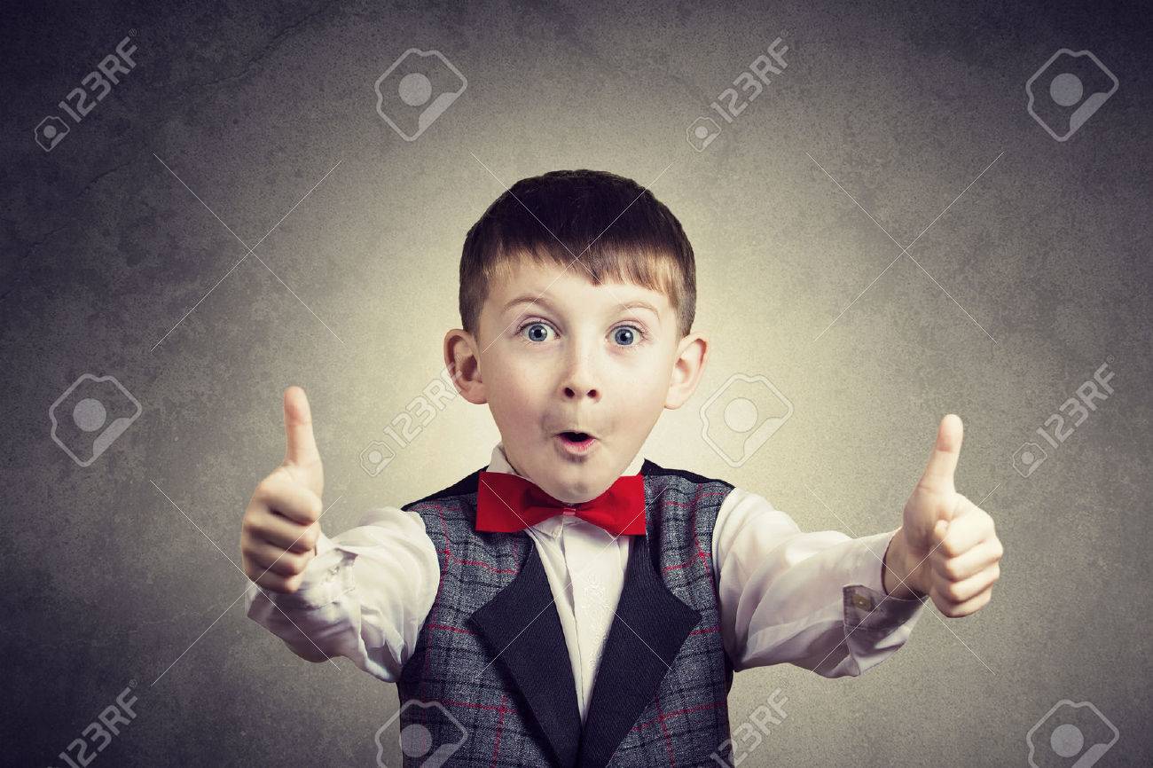 Excited Surprised little boy with thumb up gesture isolated over grey background. - 50460746 Excited Surprised little boy with thumb up gesture isolated over grey background. - 50460746