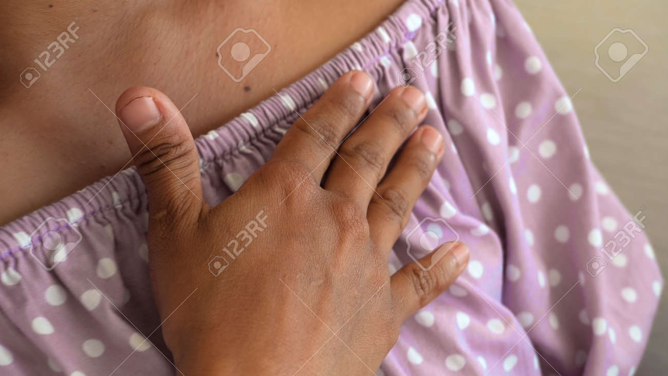 A young girl touches a violet dress sitting on a couch in the house with her hand - 171458553 A young girl touches a violet dress sitting on a couch in the house with her hand - 171458553