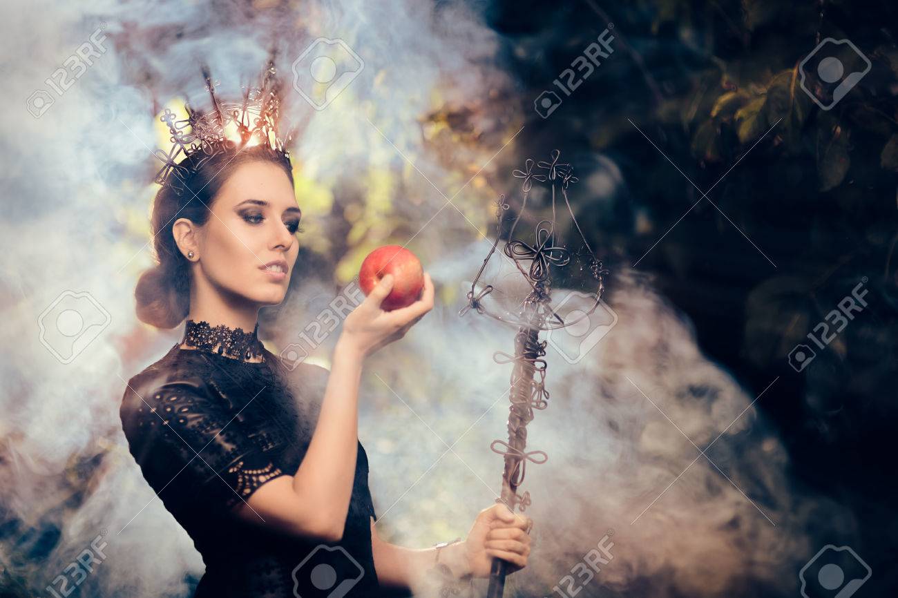 Evil Queen with Poisoned Apple in Misty Forest - 62925379 Evil Queen with Poisoned Apple in Misty Forest - 62925379