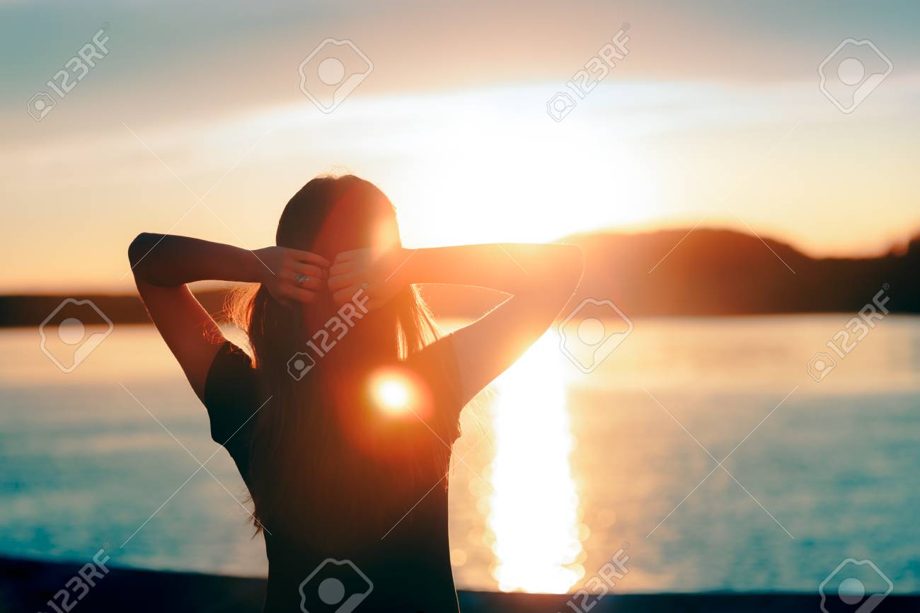 Happy Hopeful Woman Looking at the Sunset by the Sea - 94363434 Happy Hopeful Woman Looking at the Sunset by the Sea - 94363434
